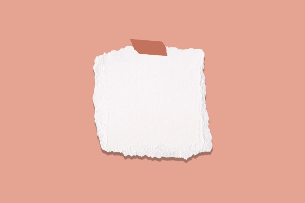 torn white paper taped on pink background